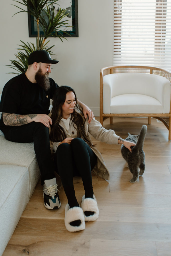 boyfriend and girlfriend enjoy time together in their first home with their cat