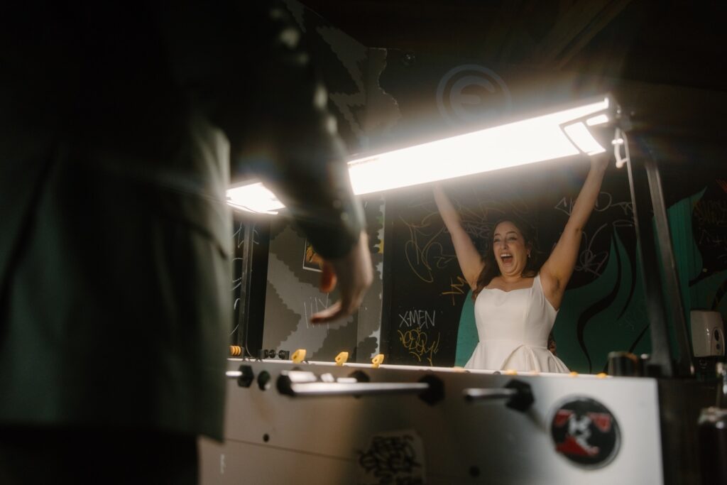 A bride celebrates after winning around of foosball on her wedding day in a Chicago bar