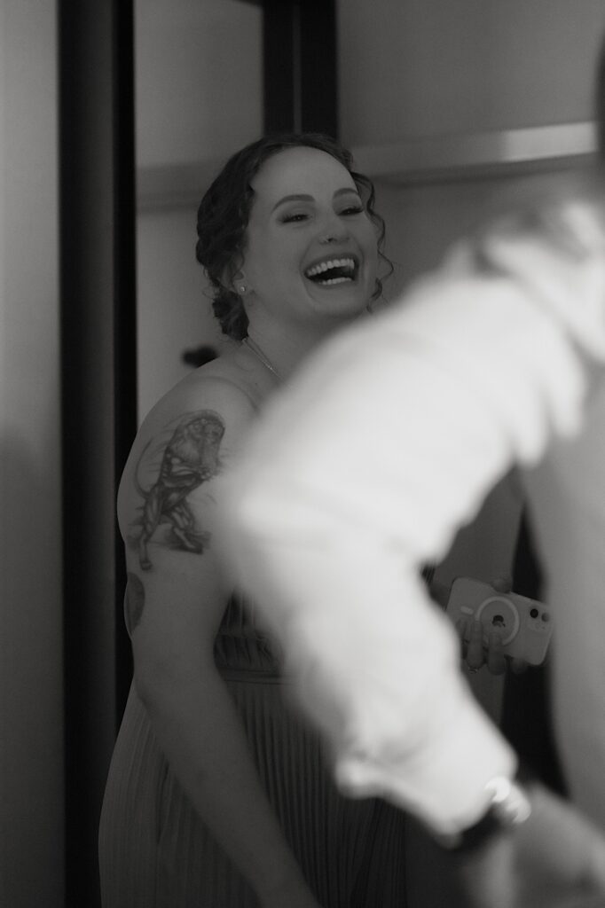 The sister of the groom laughs at the groom as he gets ready in his Chicago hotel.