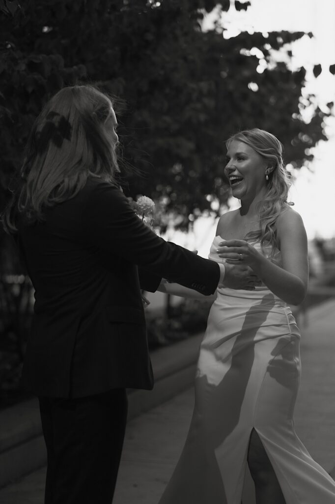 A bride and groom see one another for the first time on their wedding day.  The brides pleated dress looks beautiful in the shadows of the cloudy Chicago wedding day. 