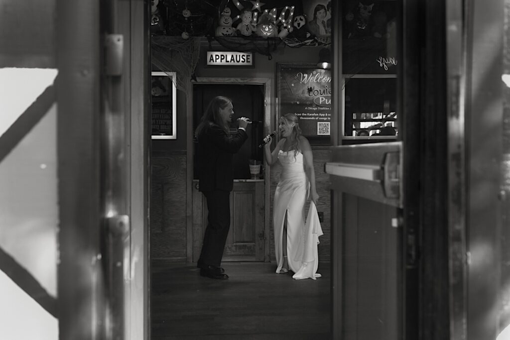 A bride and groom sing karaoke together the afternoon before their wedding in a dive bar in Chicago. 