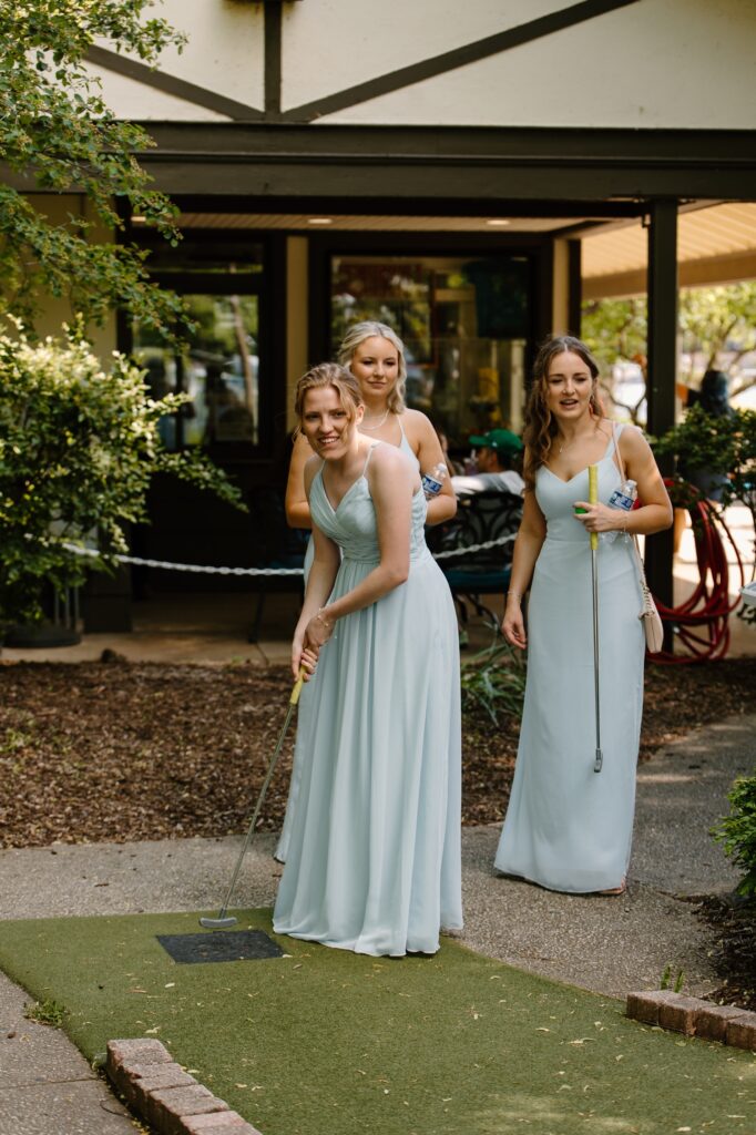 Bridesmaids in sea foam green play mini golf with the bride and groom on their Chicago wedding day.  