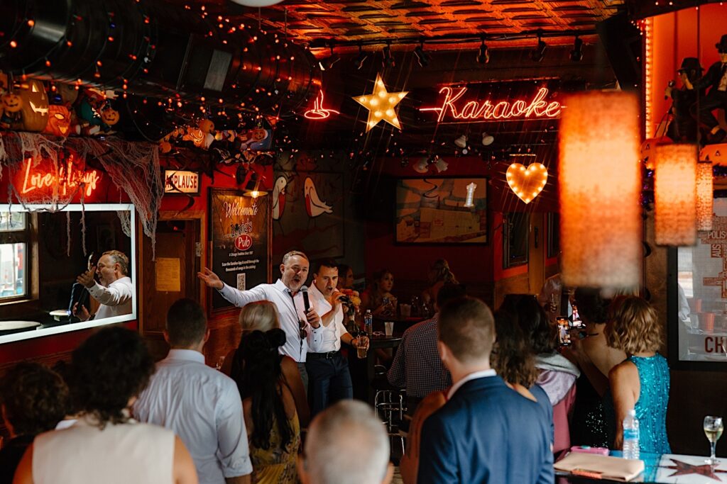 Wedding guests sing karaoke together at a dive bar in Chicago.