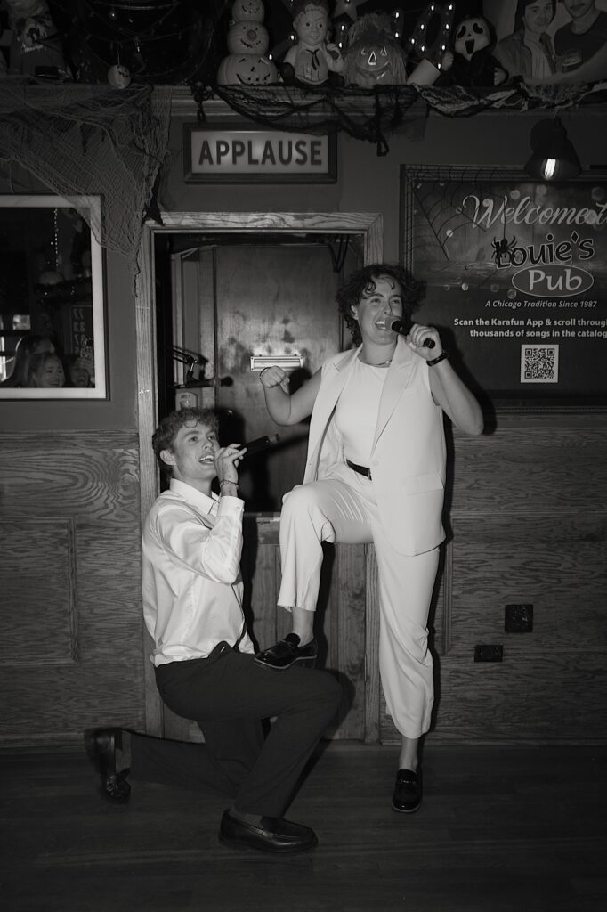 Two wedding guests sing together and pose for a photo at Louie's Pub in Chicago. 