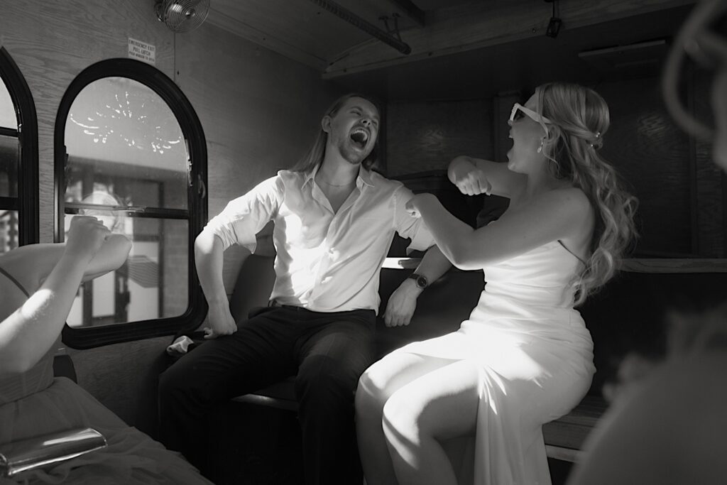 A bride and groom sing and dance together on their Chicago wedding trolley on their wedding day.  