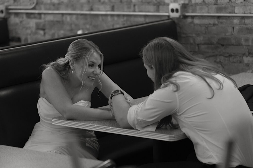 A bride and groom sit together holding hands and laughing as they mentally prepare for their wedding ceremony at Homestead on the Roof in Chicago. 