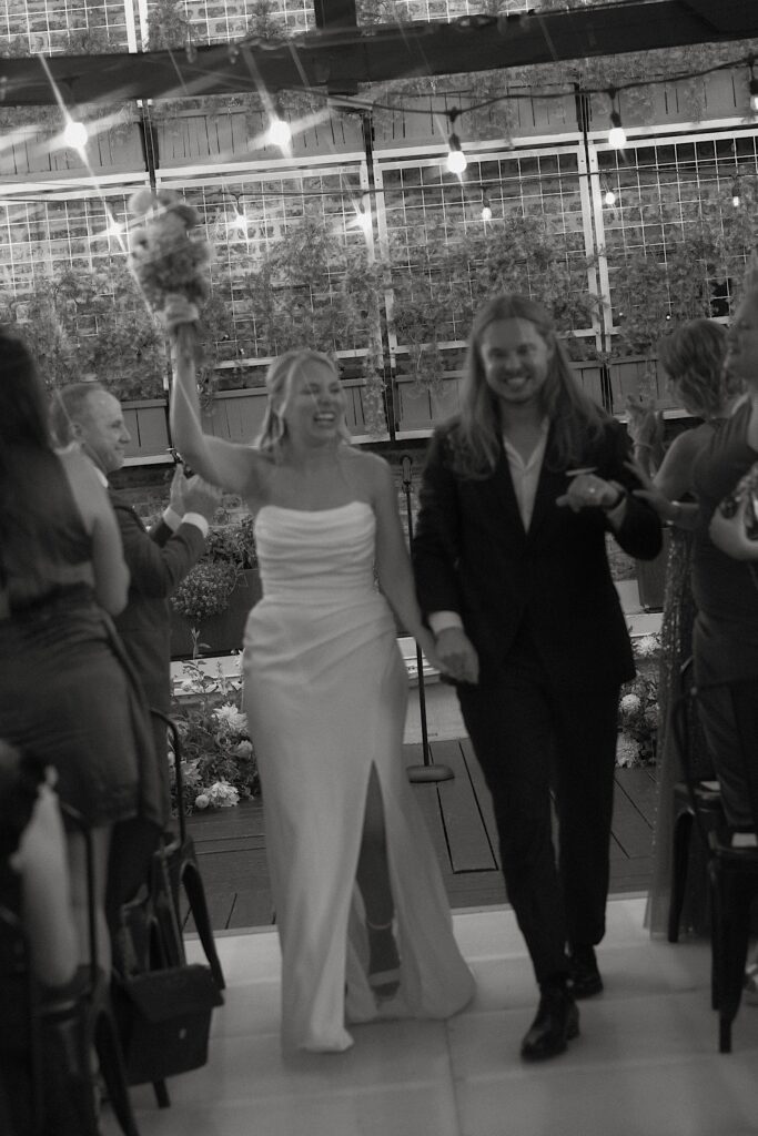 A blurry image of a bride and groom celebrating as they exit their wedding ceremony space on a Chicago rooftop.