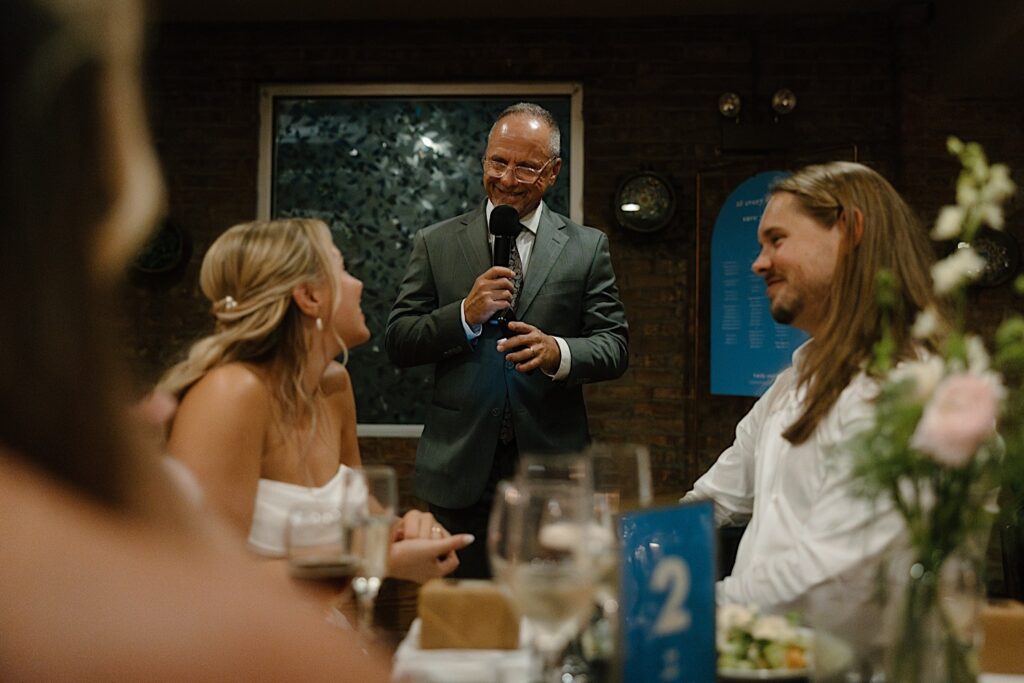 The father of the bride gives a toast during their intimate wedding reception at Homestead on the Roof. 