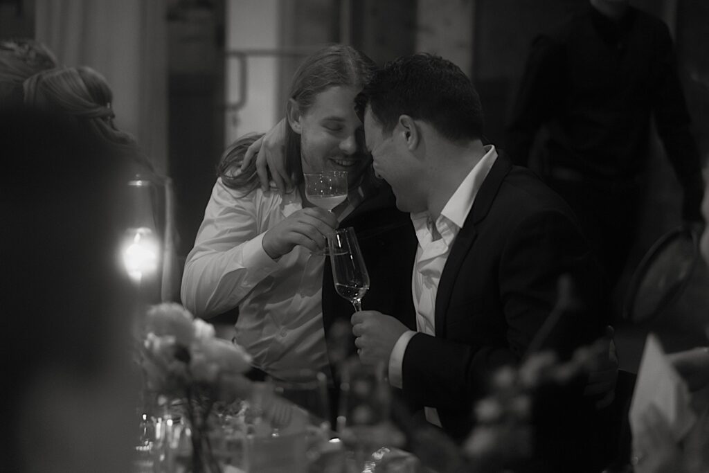 The groom toasts one of his groomsmen during dinner at their wedding reception in Chicago. 