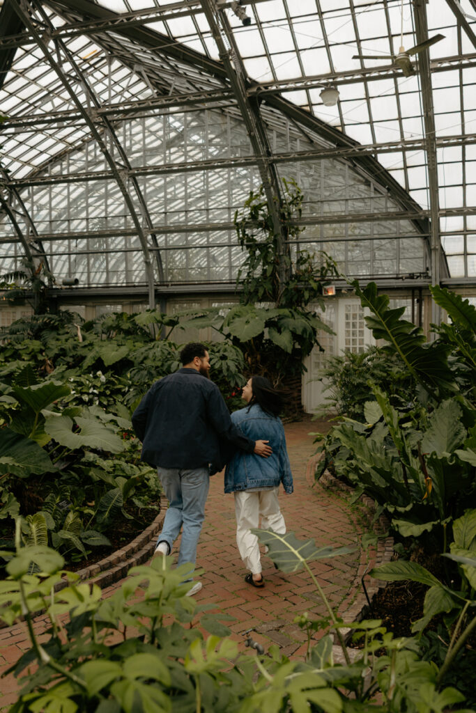 A couple runs away through the Garfield Park Conservatory.