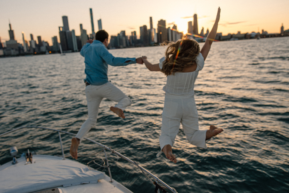 a couple jumping off a boat into the Chicago harbor
